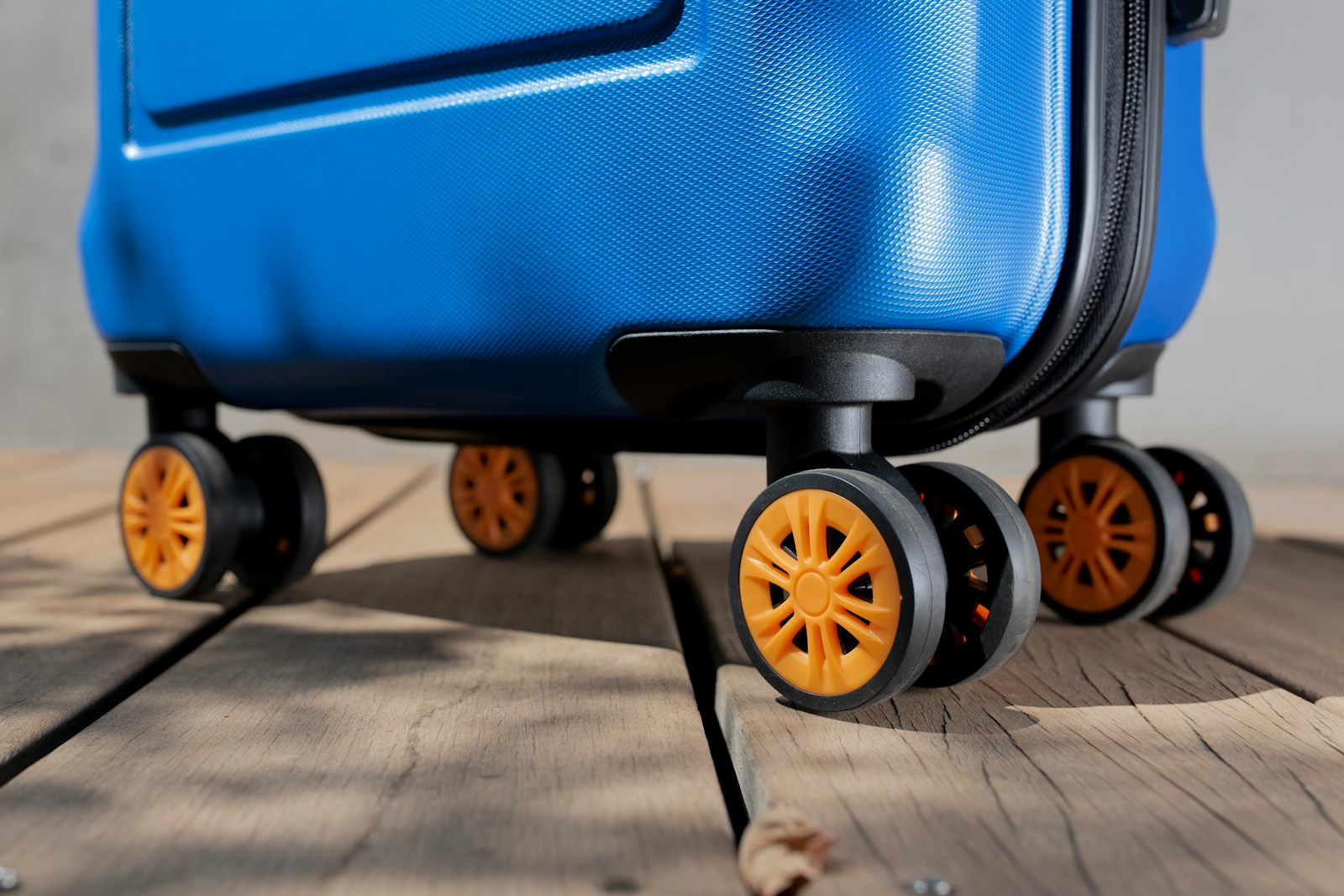 a blue piece of luggage sitting on top of a wooden floor
